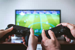 兩名玩家在足球電子遊戲比賽中手持遊戲控制器。 — 賽車 壁紙