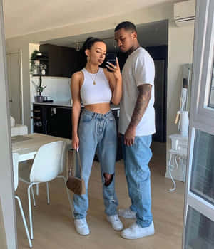 穿著白色上衣和破洞牛仔褲的情侶在現代公寓中對著鏡子自拍。