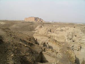 沙漠景觀中的古代金字形神塔遺跡，散落著磚地基。