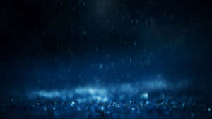 深藍色的夜晚下雨，靠近地面有發光的薄霧。
