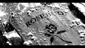 被雪覆蓋的墓碑，帶有玫瑰徽章和刻字rosebud