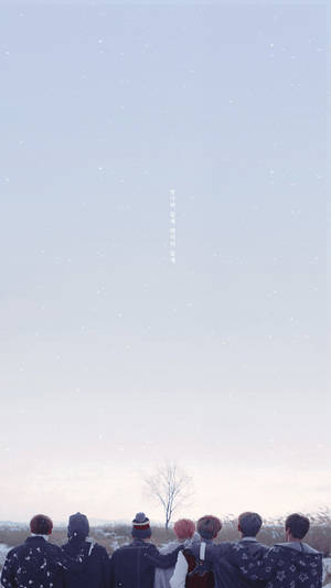 六個朋友裹著冬季外套，一起站著仰望下雪的天空。 — 冬天桌面 壁紙
