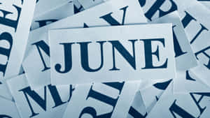 一堆白色卡片，上面有海軍藍字母拼出 JUNE