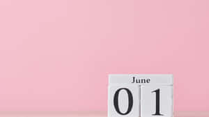 白色木製日曆塊，在粉紅色背景上顯示6月1日。