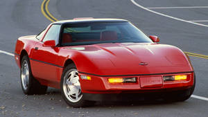 日落時紅色Corvette跑車停在瀝青路上。
