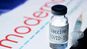 一個標有 moderna 的 COVID-19 疫苗小瓶，旁邊有一支注射器。
