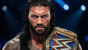 Roman Reigns在場館聚光燈下手持WWE冠軍腰帶。 — Roman Reigns 壁紙