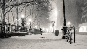夜晚在白雪覆蓋的城市公園中，在街燈下獨自行走的人。