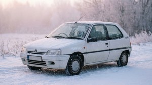 白色復古車停在雪地上，下雪中