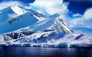 白雪皚皚的山脈在明亮的天空下倒映在平靜的藍色海水中。 — 冰島 壁紙
