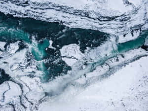 鳥瞰圖：一條碧綠色的河流流經雪山和冰層結構。