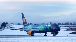 冰島航空飛機帶有極光塗裝在積雪跑道
