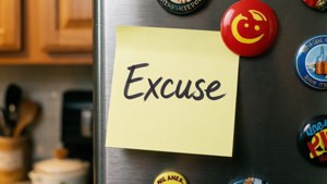 一張手寫的便條，上面寫著「Excuse」，貼在一個有磁鐵的雪櫃上。