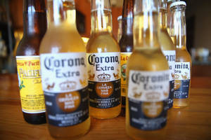 木質吧檯上Corona Extra和Pacifico啤酒瓶的特寫。 — 3:2 壁紙