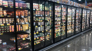 光線充足的雜貨店內設有玻璃門和價格標籤的冷凍食品通道。