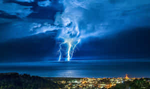 閃電照亮了沿海小鎮和海洋上空的暴風雨之夜。