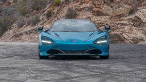 青綠色McLaren 720S跑車在山路上。