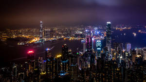 夜間香港天際線，燈火通明的摩天大樓和海港燈光。