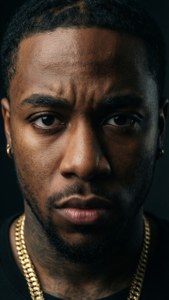 男人戴著金鏈和耳環，在黑暗的攝影棚中強烈地看著相機。 — Lil durk GIF 壁紙