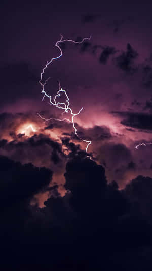 一道明亮的閃電照亮了夜晚黑暗的暴風雨雲層。