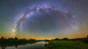 在星空下，銀河系反射在平靜的河流中。