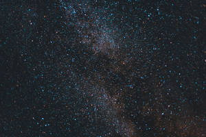 在黑暗的夜空中，銀河系帶有藍色和橙色的星星。
