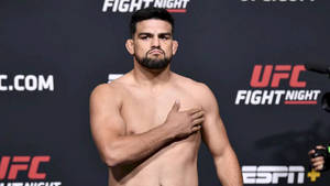 UFC拳手在稱重活動中赤裸上身，手放在胸口擺姿勢。