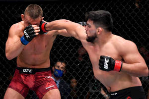 兩名男性拳手在UFC籠中進行綜合格鬥比賽時交換強力一拳。
