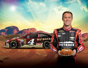 NASCAR車手奇雲夏域在沙漠日落時分，拿著一籃雞肉站在他的賽車旁。