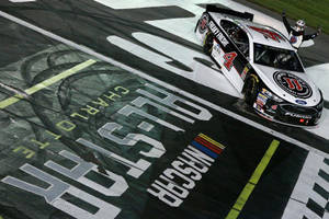 NASCAR賽車越過終點線，車手在夜間慶祝勝利。