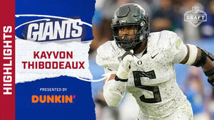 身穿白色球衣的足球運動員 Kayvon Thibodeaux 在 NFL 選秀亮點中奔跑。