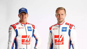 兩位身穿賽車服的Haas F1車手正在擺姿勢拍照。