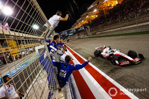 賽車隊慶祝勝利，F1賽車在夜晚衝過終點線。