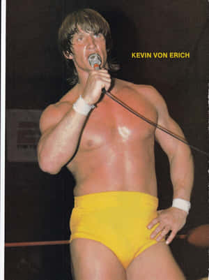 摔角手 Kevin Von Erich 穿著黃色短褲在舞台上握著麥克風。 — 摔角 GIF 壁紙