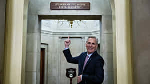 身穿西裝的凱文·麥卡錫在政府走廊中，在「Speaker of the House」標誌下向上指。