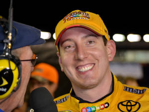 穿著黃色M&M's制服的NASCAR車手在夜間採訪中微笑。 — 微笑 壁紙