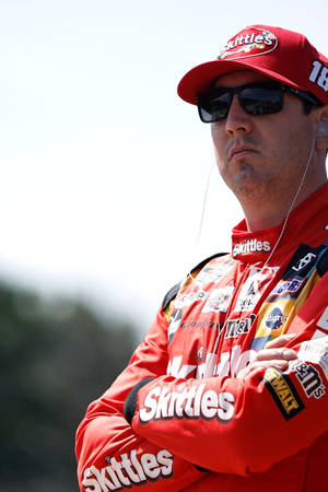 身穿紅色Skittles制服的NASCAR車手在戶外交叉雙臂。