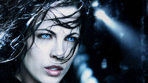 特寫一位擁有引人注目的藍眼睛和濕頭髮的女性，在深藍色燈光的場景中。 — 深藍色 壁紙