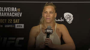 女性MMA拳手在UFC新聞發布會上拿著麥克風。 — 昏暗 壁紙
