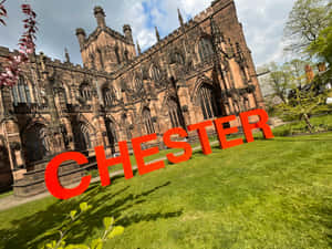 在歷史悠久的石頭大教堂前的草地上，紅色的「CHESTER」字母。