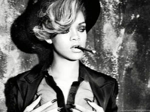 Rihanna 的黑白照片，戴著帽子和手持香煙。
