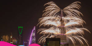 煙花在夜晚發光的城市天際線上空爆發。 — 煙火 壁紙