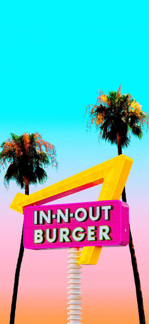 一個明亮的In-N-Out Burger霓虹招牌，棕櫚樹襯托著色彩繽紛的天空。