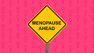 粉紅色背景上帶有女性符號的黃色警告牌，寫著「Menopause Ahead」。