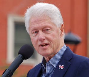 比爾·克林頓在戶外活動中發言，身穿藍色西裝和格仔恤衫。 — 安卓 壁紙