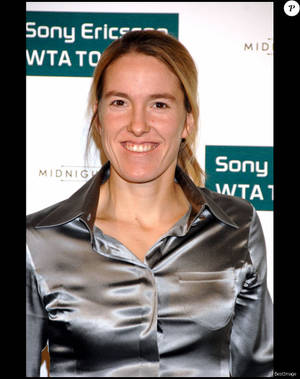 身穿銀色襯衫的女性在Sony Ericsson WTA Tour活動中微笑。 — 網球 壁紙