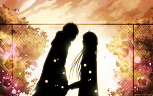 剪影動漫情侶在夕陽下隔著圍欄牽手，周圍有發光的樹葉。 — 情侶 GIF 壁紙