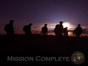 剪影士兵在黃昏時分行走，帶有「Mission Complete」文字和海軍陸戰隊徽章。 — 水下 壁紙