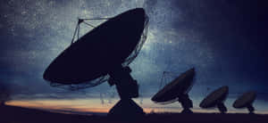 電波望遠鏡在星空暮色中呈現剪影。 — 超寬螢幕 壁紙