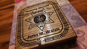 刻有副警長星章和名字 John M Walsh 的木製餅乾盒。